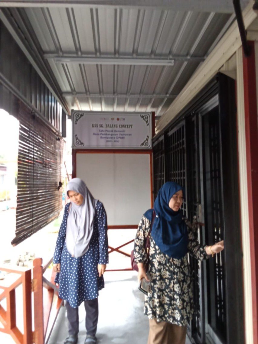 Dr. Liza binti Md Salleh bersama Nur Izzaty Amira binti Md Jais di pintu hadapan Pejabat Jualan Koperasi, Sungai Balang.